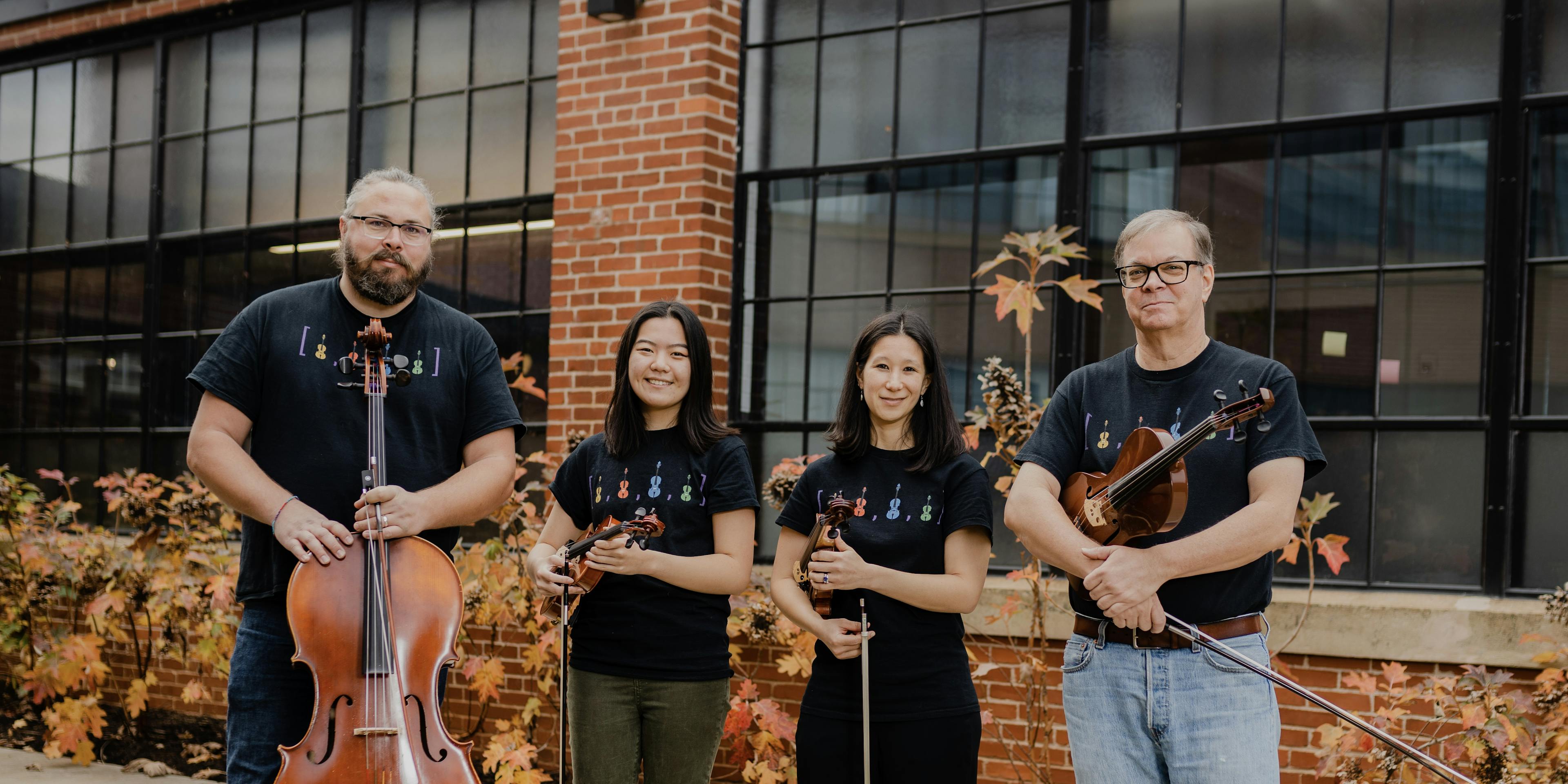 An Array of Strings Quartet standing outside in T-shirts