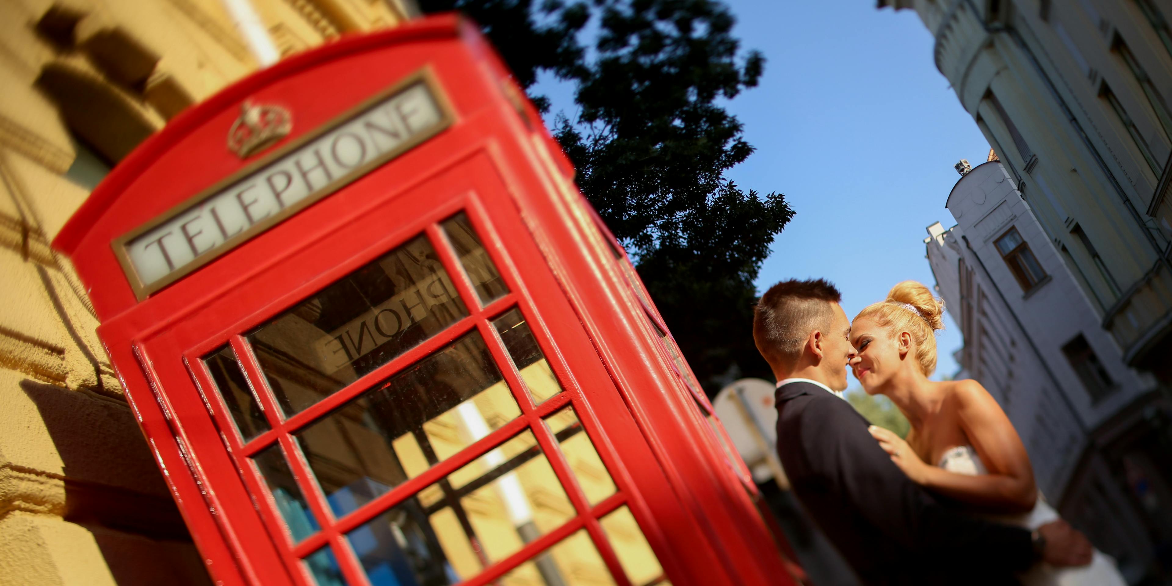 newlywed couple next to English phone booth